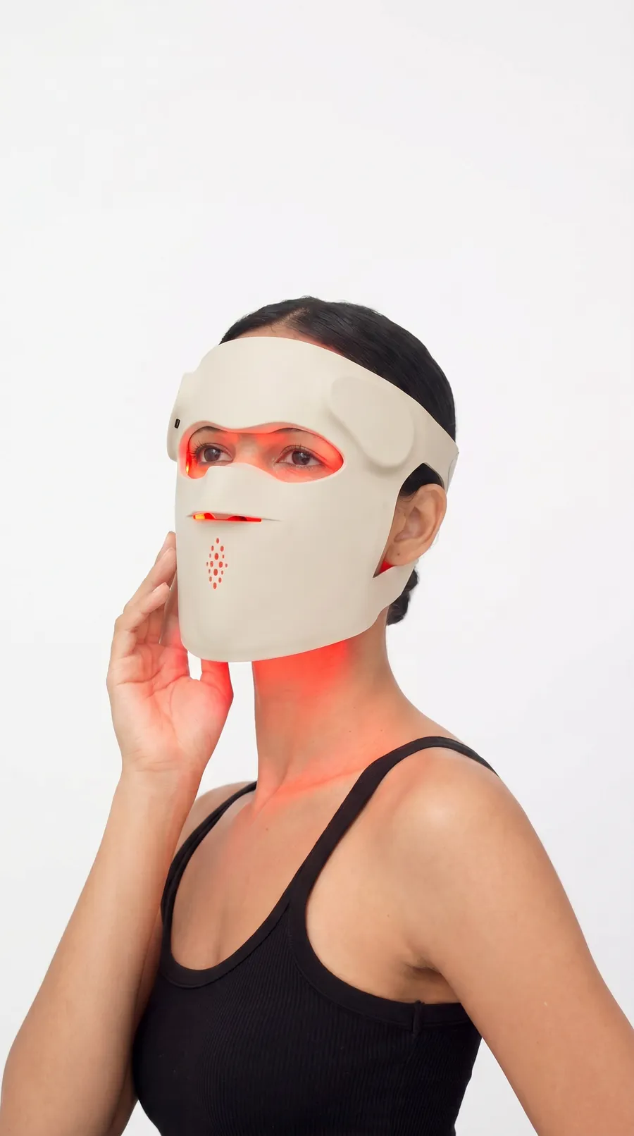 A person wearing a full-face flexible LED mask during a session